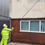 Worker cleaning outside building