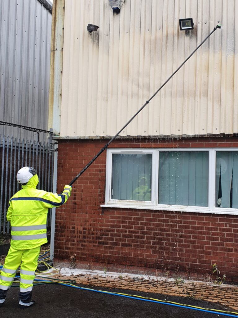 Worker cleaning outside building